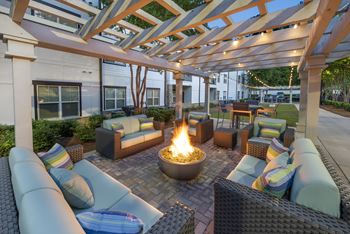 A patio with a fire pit and seating area.